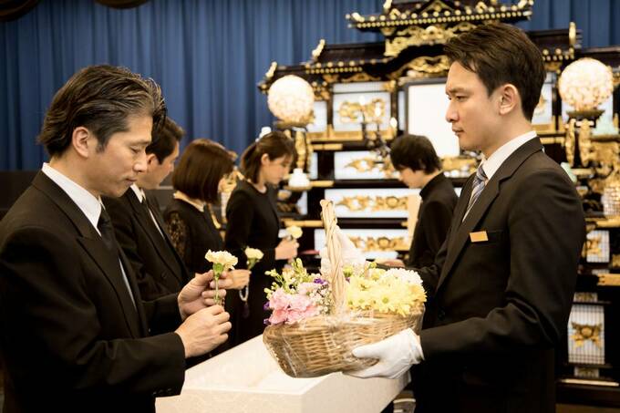 葬式でお花を持つ人