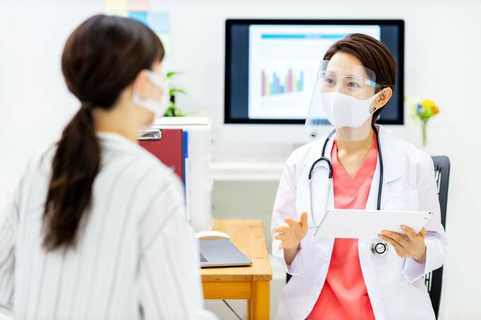 フェイスシールドをつける医者