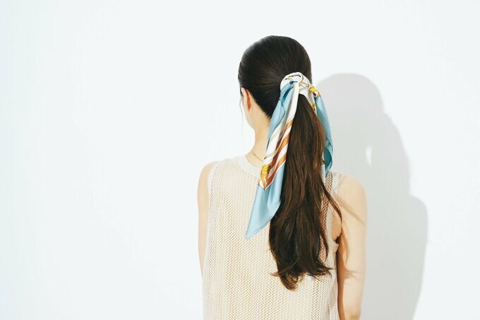 ポニーテールにスカーフを巻き付けた女性の後ろ姿