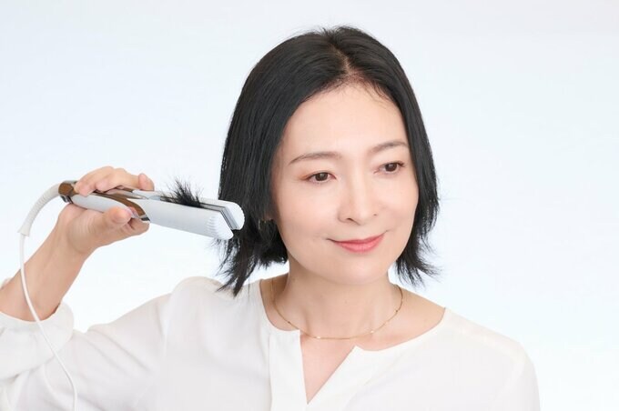 アイロンで毛先を外ハネにする女性