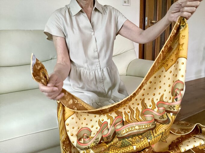 スカーフの一片の両端を持つ