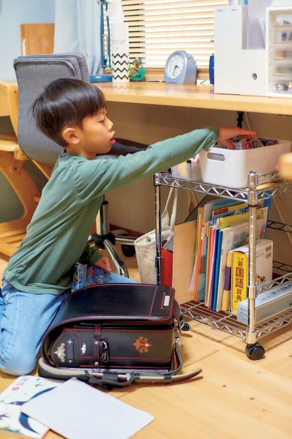 床に座って持ち物を入れ替える男の子