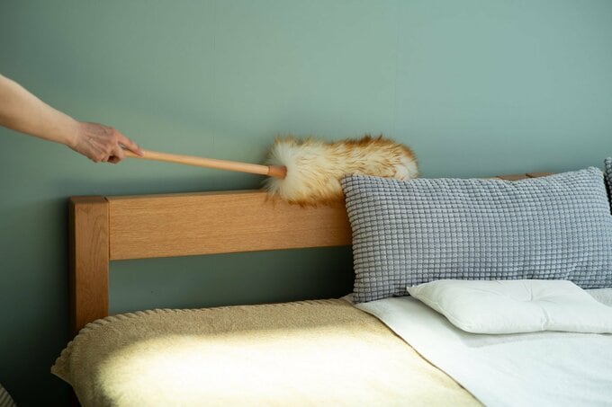 ベッドボードにはたきをかける