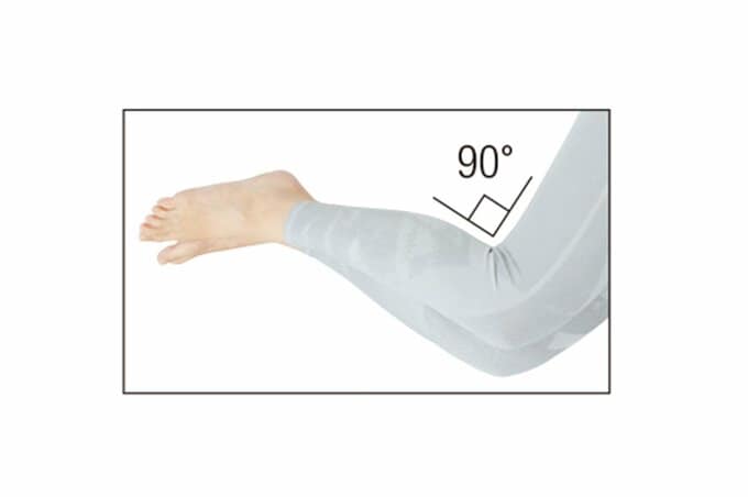 横たわっている女性の、ひざが90度に曲がった脚