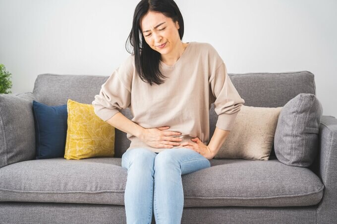 おなかをおさえる女性
