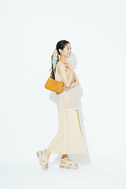 白のワンピースと厚底サンダルを身に着けた女性