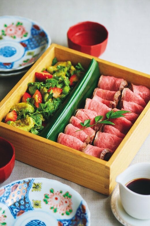 重箱に詰められたローストビーフと春菊とイチゴのあえもの