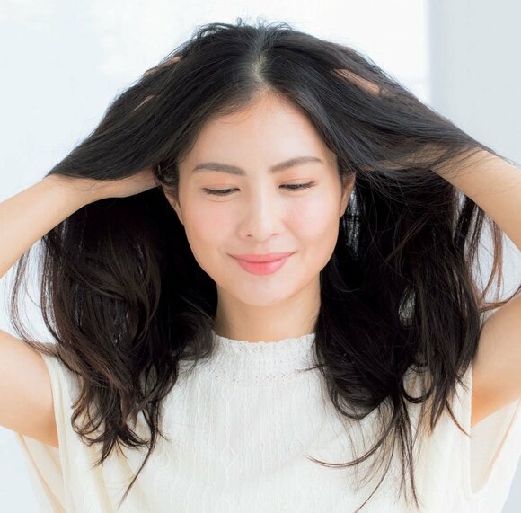 女性両手で髪を持ち上げる