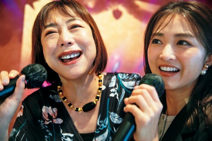 マイクを持って歌う2人の女性