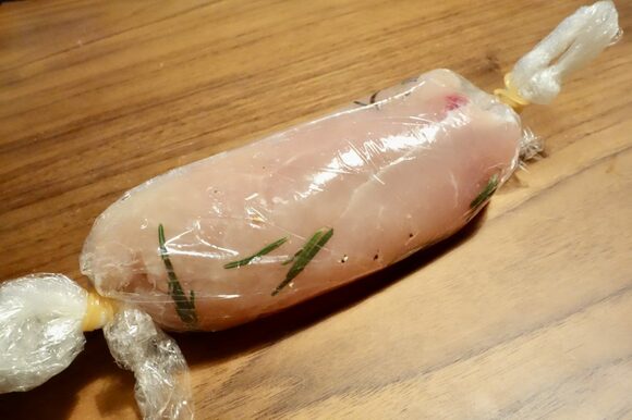 ラップを敷いた上にお肉を置き、手巻き寿司の要領で強めにクルクルと巻きます