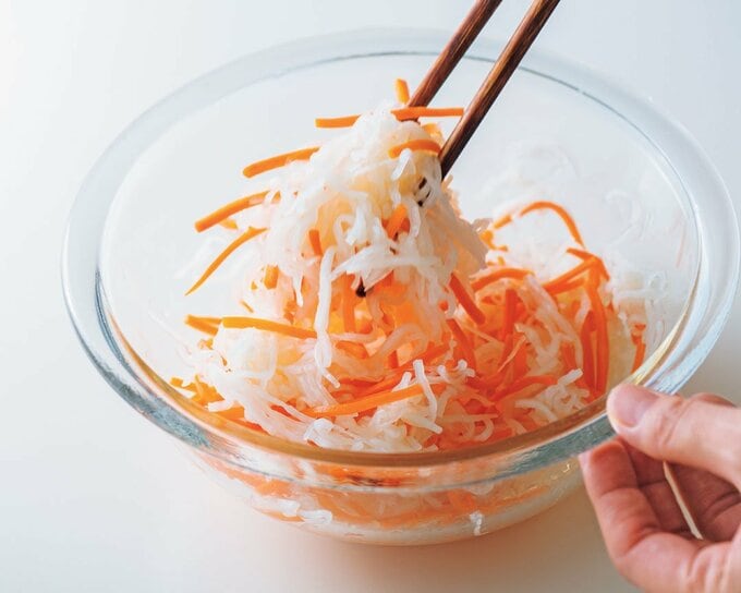 大根とニンジンを箸であえる