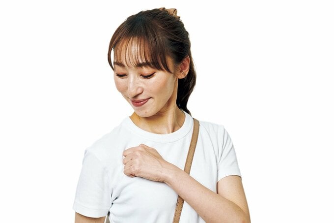 手をグーにして肩の前側の筋肉をほぐす女性