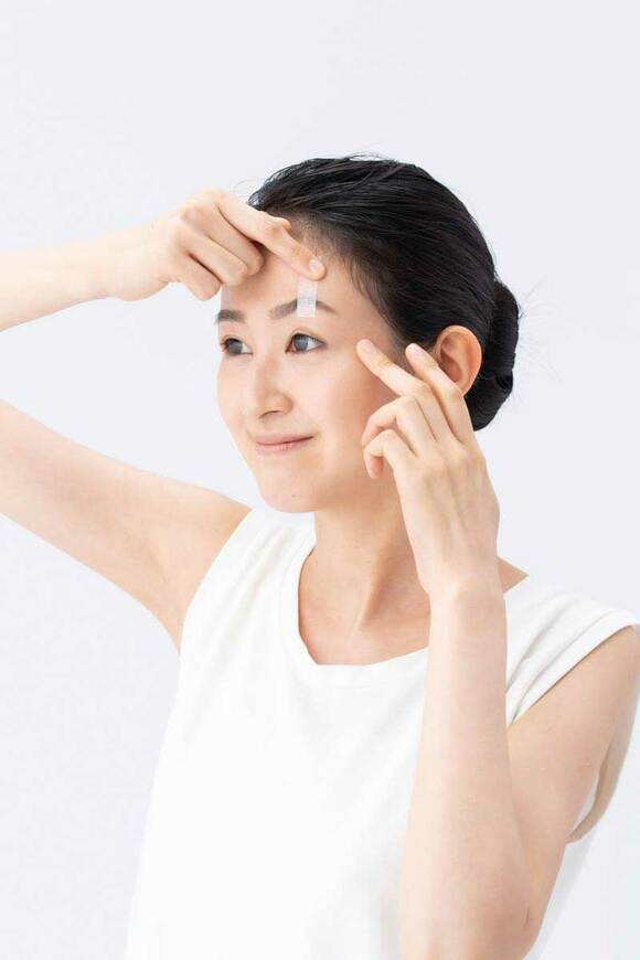 片手でまぶたを引き上げる