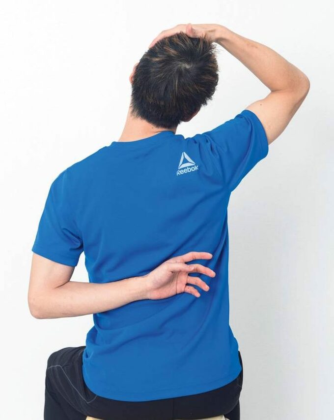 イスに座った男性右手は頭