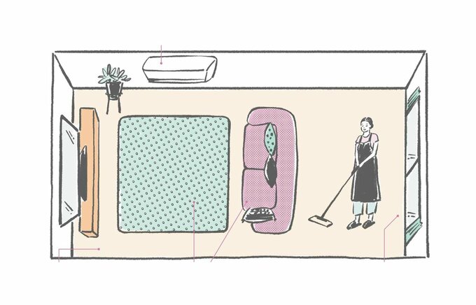 リビングで掃除機をかける女性