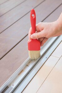 サッシにたまったホコリをハケブラシでかき出す