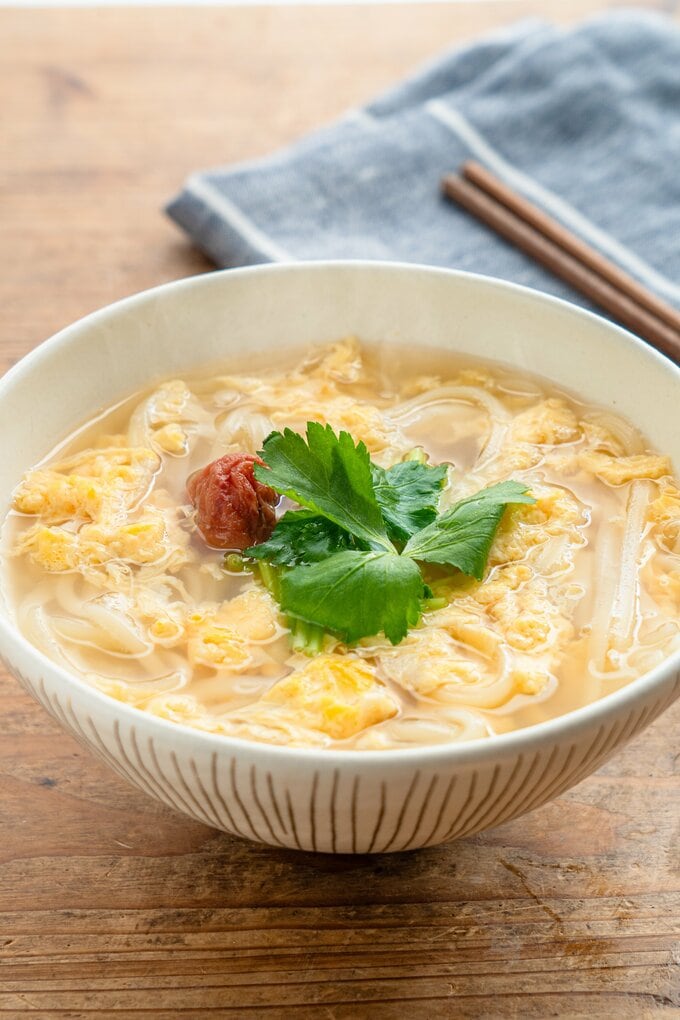 器に盛ったうどんに三つ葉と梅干しがのっている