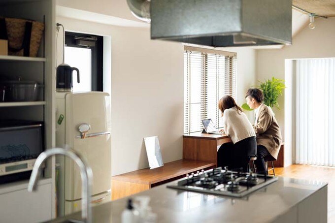 リビング窓際のカウンターでテレワークする夫妻