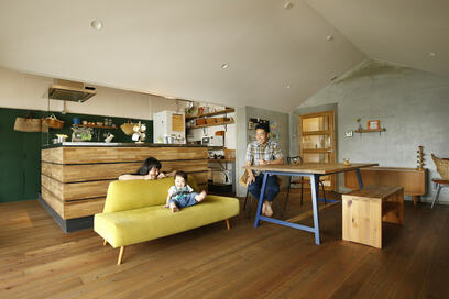 大きなテーブルに家族が集う三角屋根の家