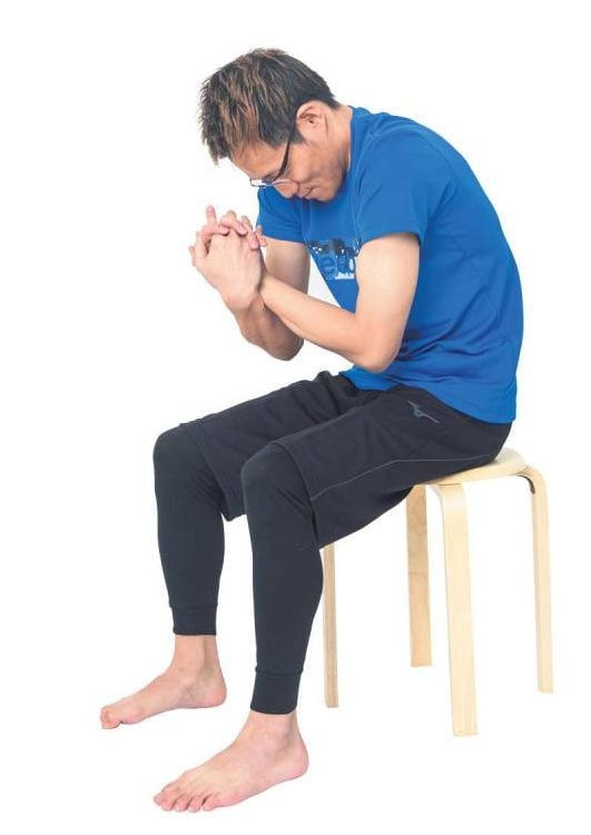 イスに座ってまるくなる男性