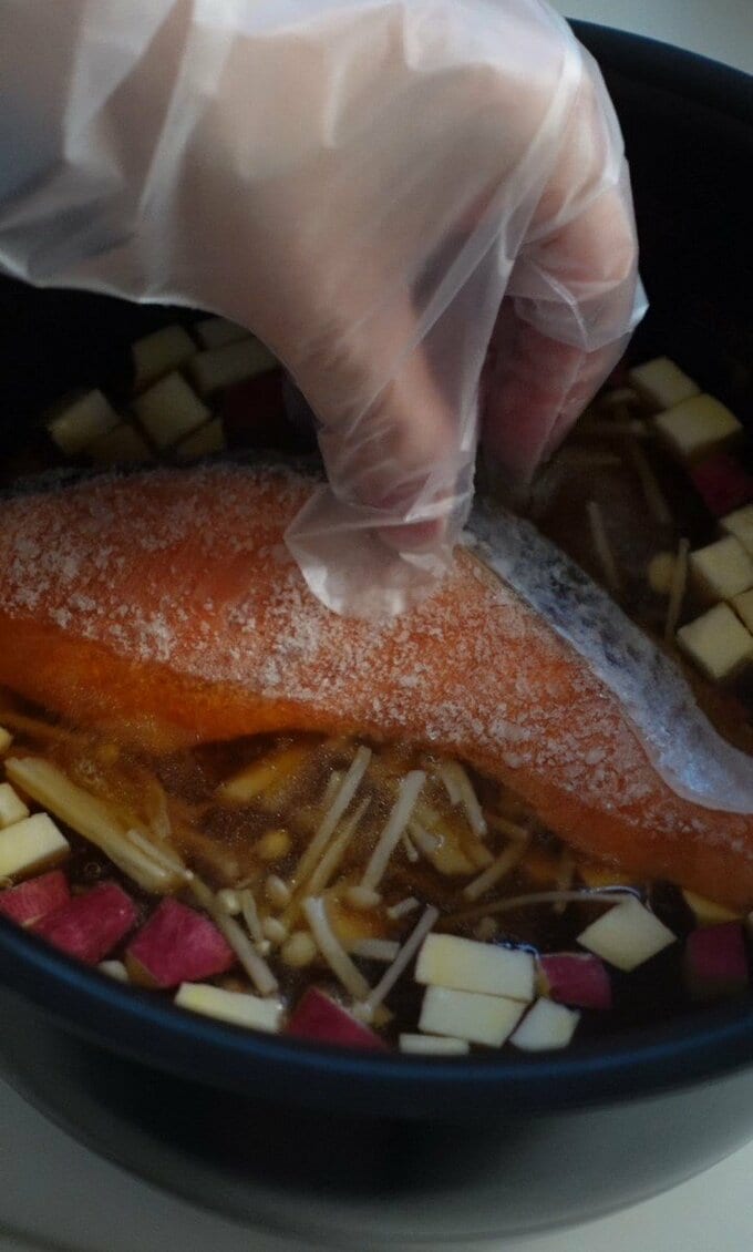 水気を切ったサツマイモ、（4）で炒めたエノキと鮭をのせ、通常通り炊飯する。