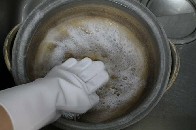 お鍋に手袋をはめた手を入れる様子