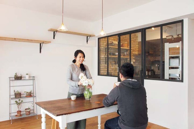 黒いガラス建具がダイニングとキッチンをゆるやかに仕切る