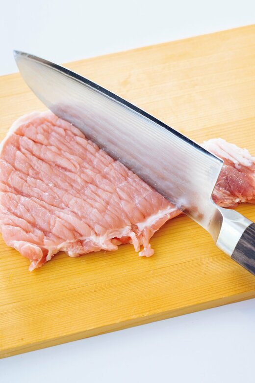 包丁の背で肉をたたく