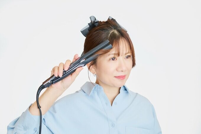 ストレートアイロンで、前髪の横の毛を後ろに流す
