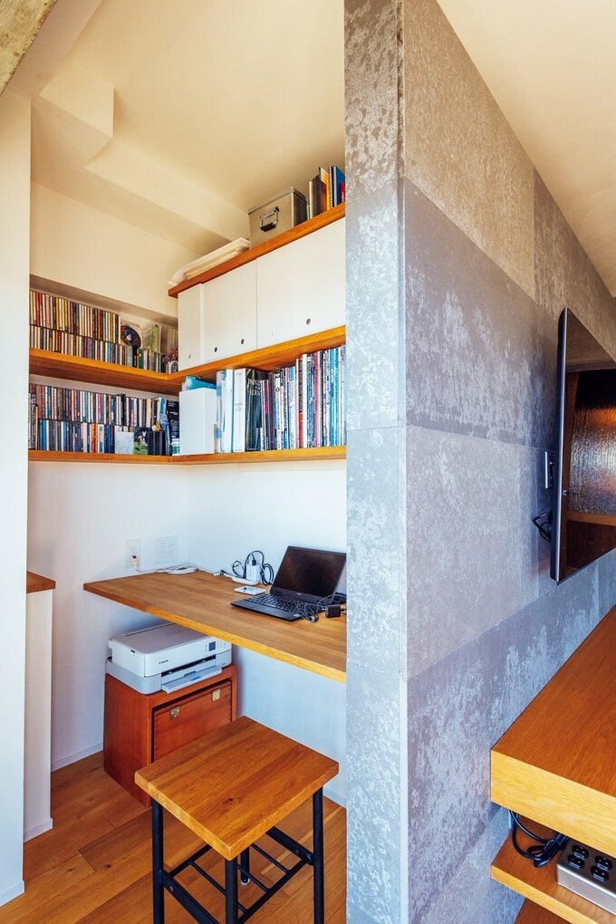 デスクとオープン収納が備わった明るいワークスペース