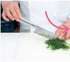 包丁の柄は親指と人さし指で軽く持ち、添え手の手首をまな板につけ、指を包丁の峰に軽く当てる