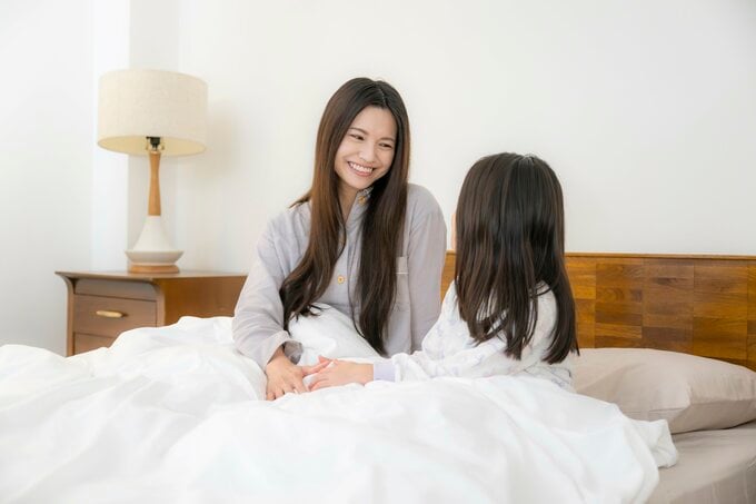 ベッドの上でほほ笑む親子