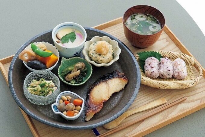 小鉢や豆皿を使ったワンプレートの食事と添えられた汁物やおにぎり