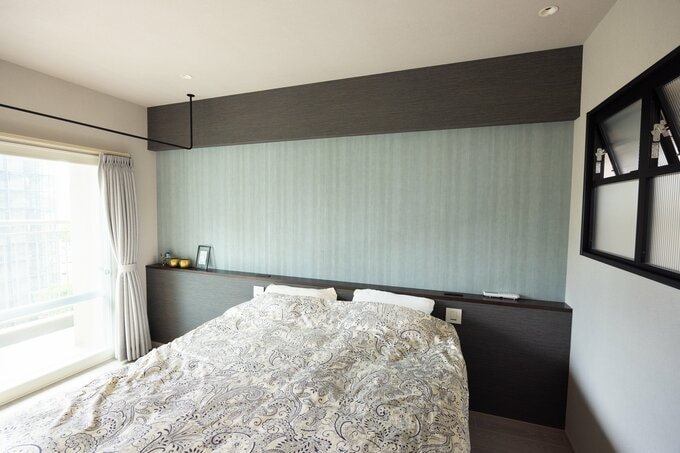 寝室はLDKとは異なるムードの空間を演出。落ち着いたブルーグリーンの壁紙をはってホテルの客室のような雰囲気に