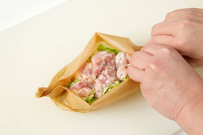 クッキングシートに鶏肉とキャベツをいれて包む