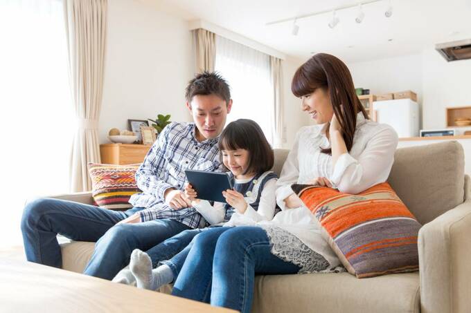 タブレットを持つ子どもとみる親
