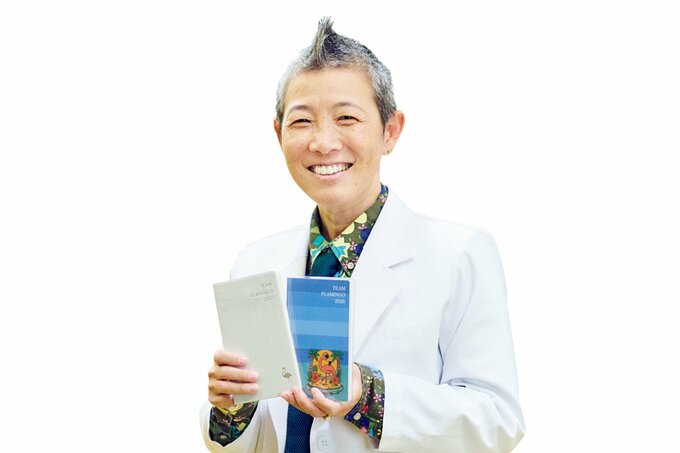 高尾先生が手帳を2冊持っている様子