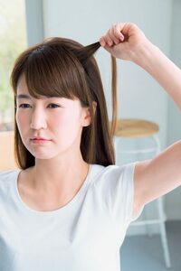 少ない毛束ひっぱる女性