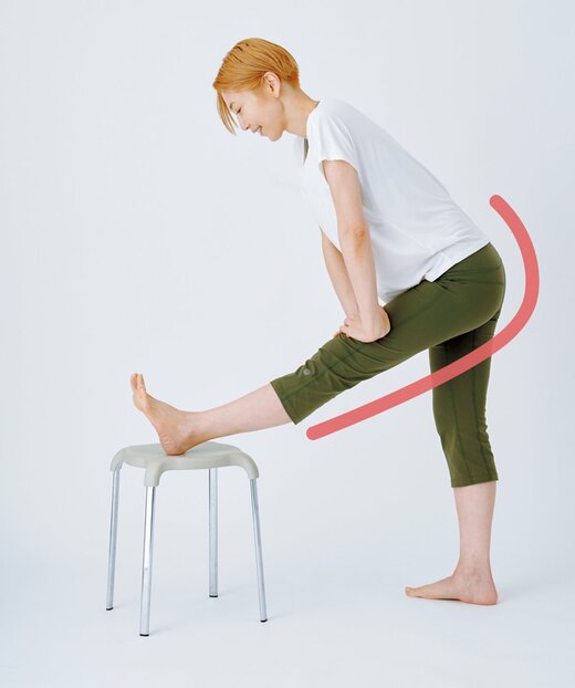 イスの上にかかとを乗せ、膀胱経、腎経を伸ばすストレッチをする柳本さん