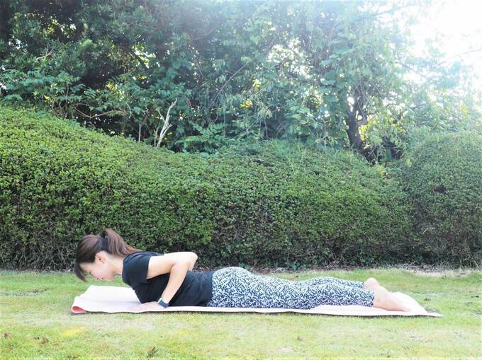 うつ伏せになり、手は胸の横に