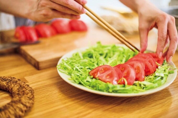 レタスとトマトを器に盛り付ける様子