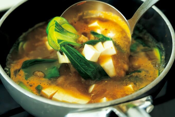 おたまで鍋からお味噌汁をすくう様子