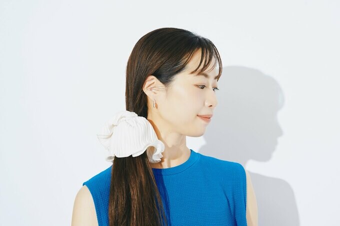 ホワイトのボリュームシュシュで髪を結んだ女性