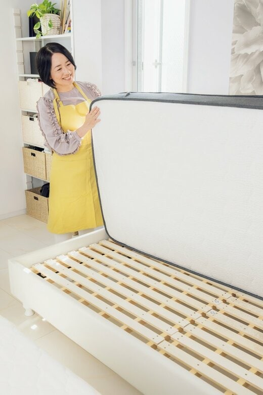 マットレスを裏返す女性