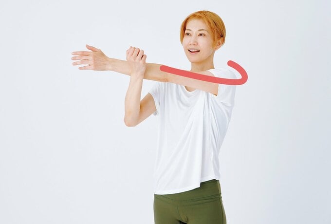 腕を横に伸ばし小腸経を伸ばすストレッチをする柳本さん