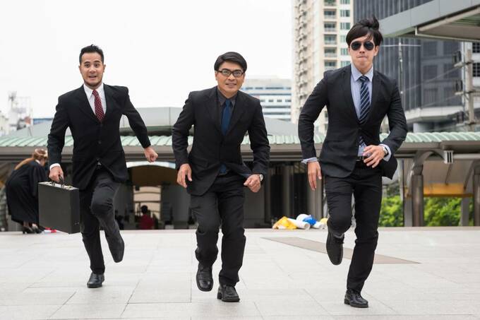 スーツの男性3人が走る様子