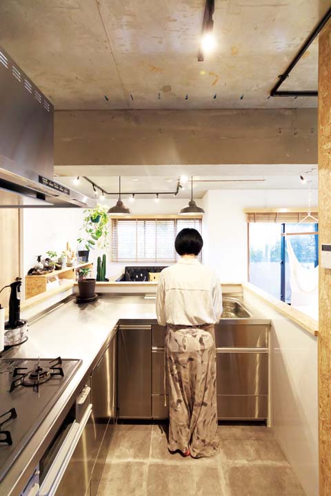 L型キッチンに立つ妻