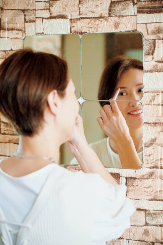 鏡の前でメイクをする女性