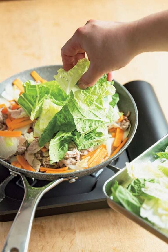 フライパンに白菜を入れる様子