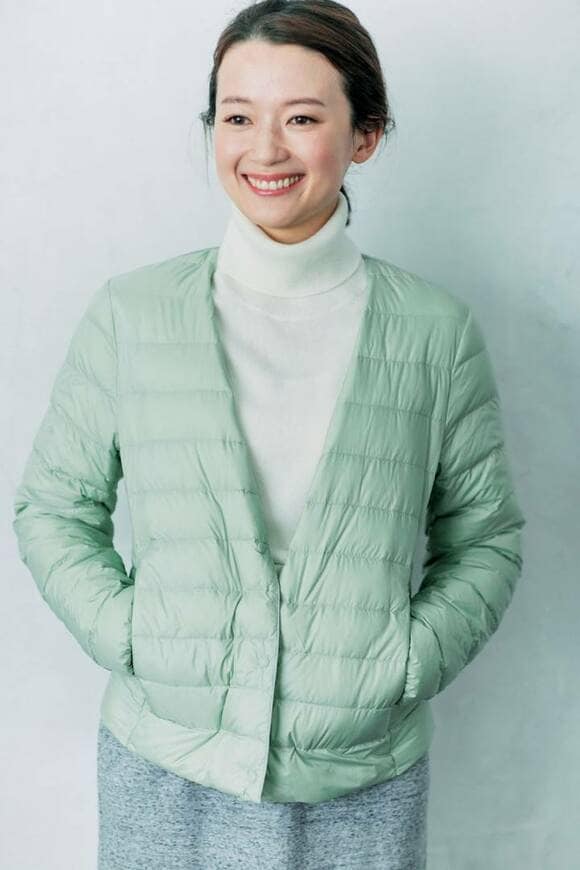 パステルダウンと白のタートルネックを着る女性